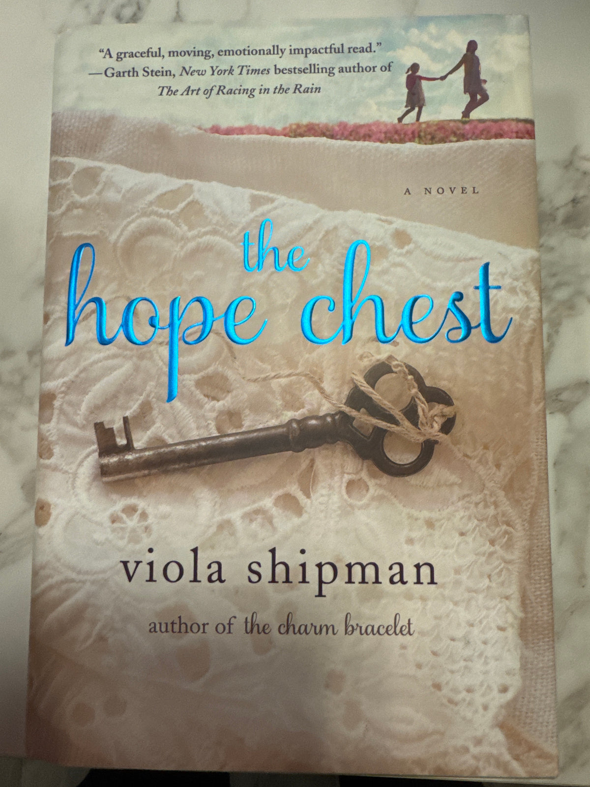 The Hope Chest novel by Viola Shipman, cream lace cover with antique key and blue cursive title
