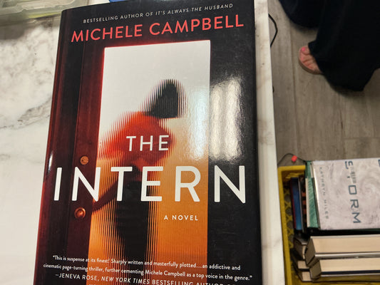 The Intern hardcover novel by Michele Campbell with black cover and orange silhouette graphic
