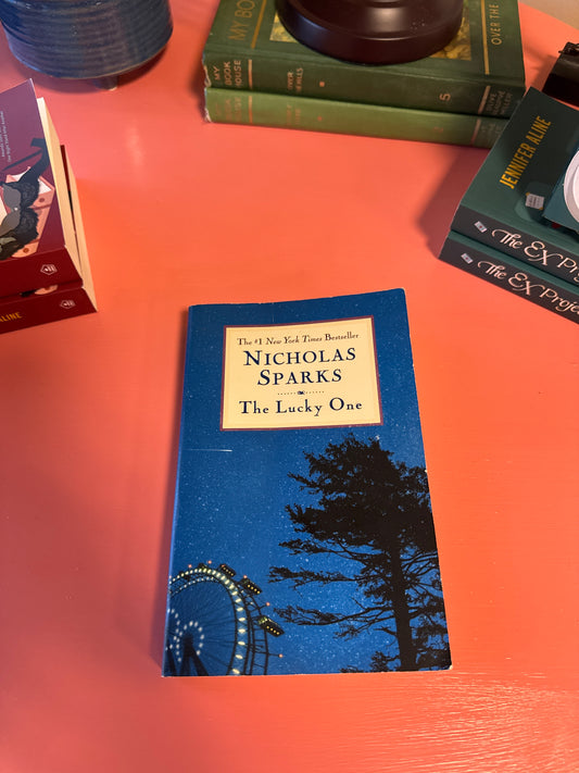 The Lucky One paperback by Nicholas Sparks with blue starry cover and Ferris wheel design