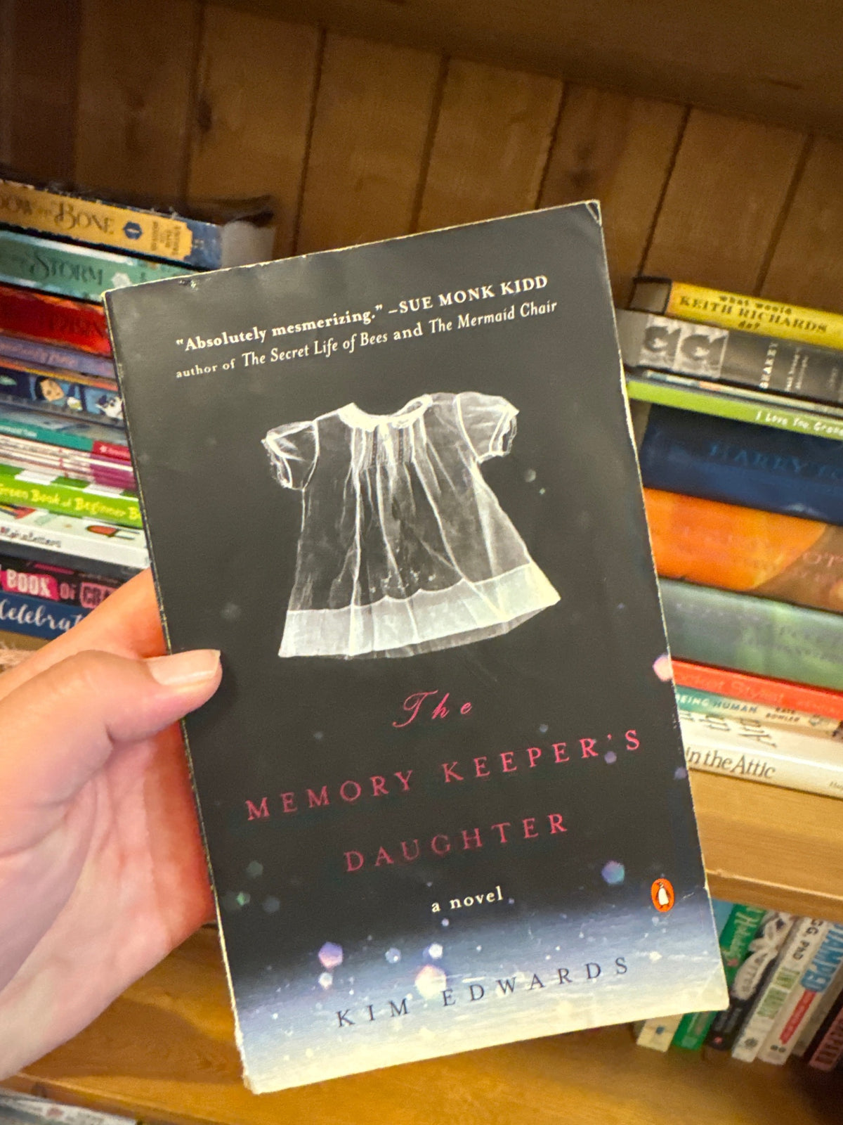 The Memory Keeper's Daughter paperback by Kim Edwards with white dress illustration on dark cover
