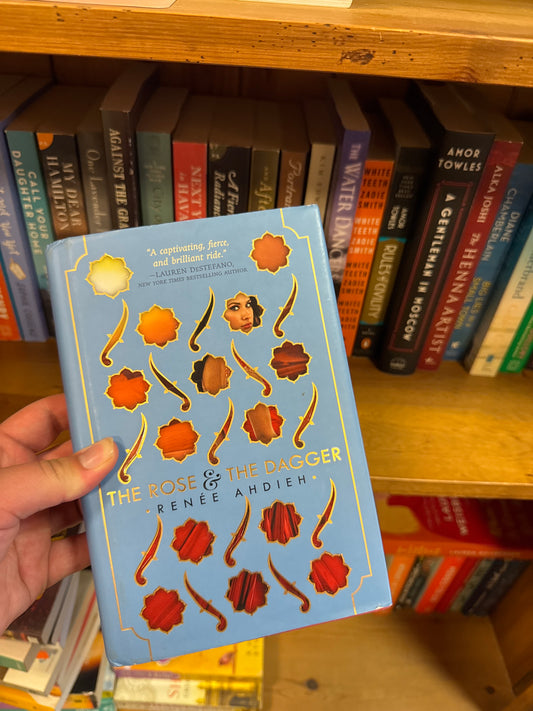 The Rose & The Dagger hardcover book by Renee Ahdieh with die-cut floral and dagger cover design