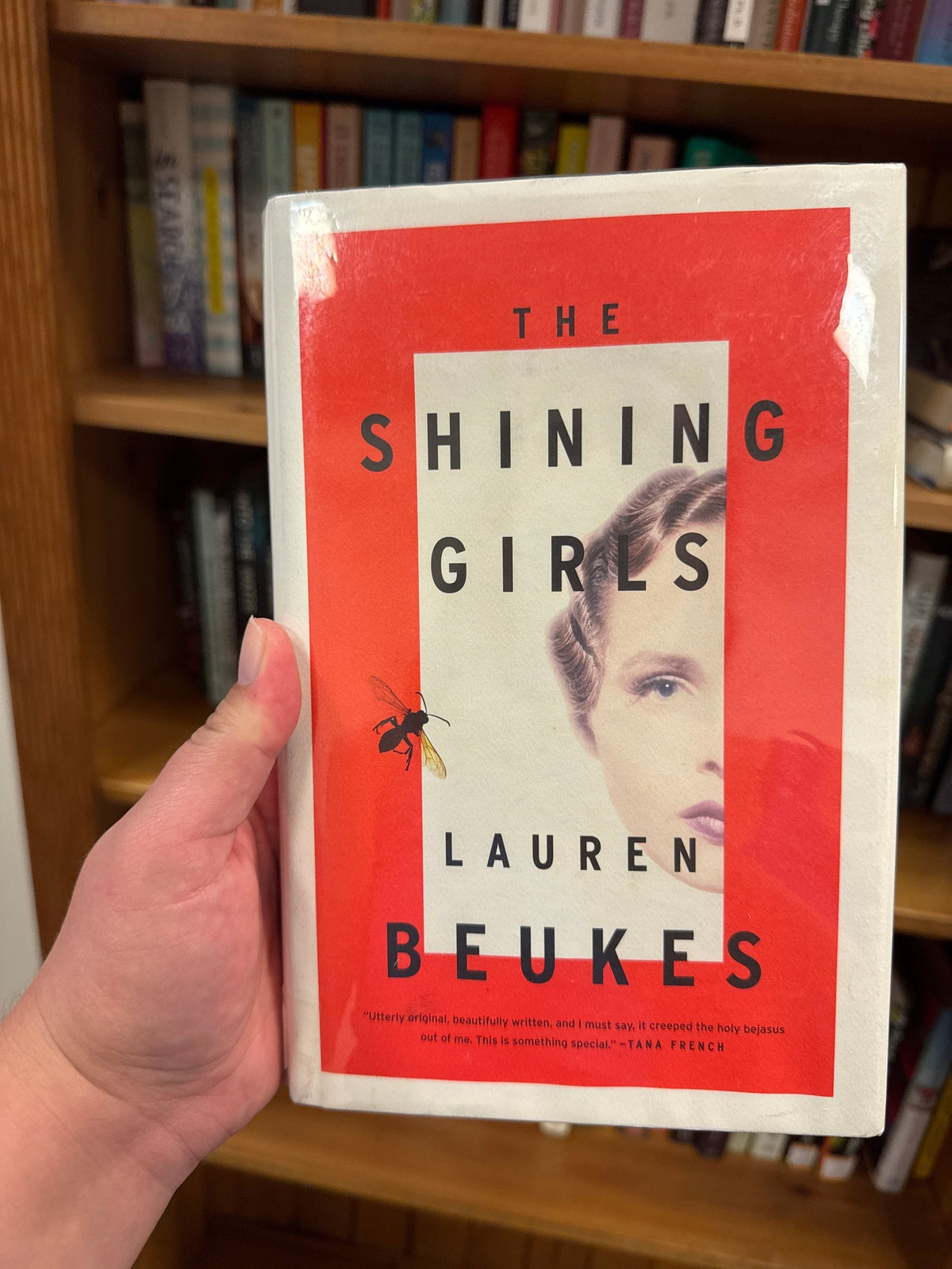 The Shining Girls hardcover book by Lauren Beukes with red and white cover art