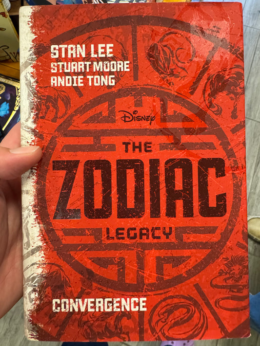The Zodiac Legacy Convergence hardcover book with distressed red and black zodiac cover art