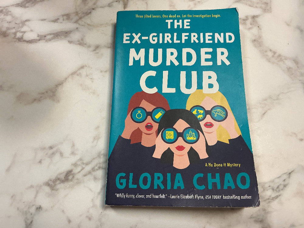 Book titled 'The Ex-Girlfriend Murder Club' by Gloria Chao on a marble surface