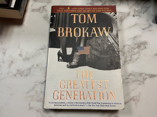 Book titled 'The Greatest Generation' by Tom Brokaw on a marble surface