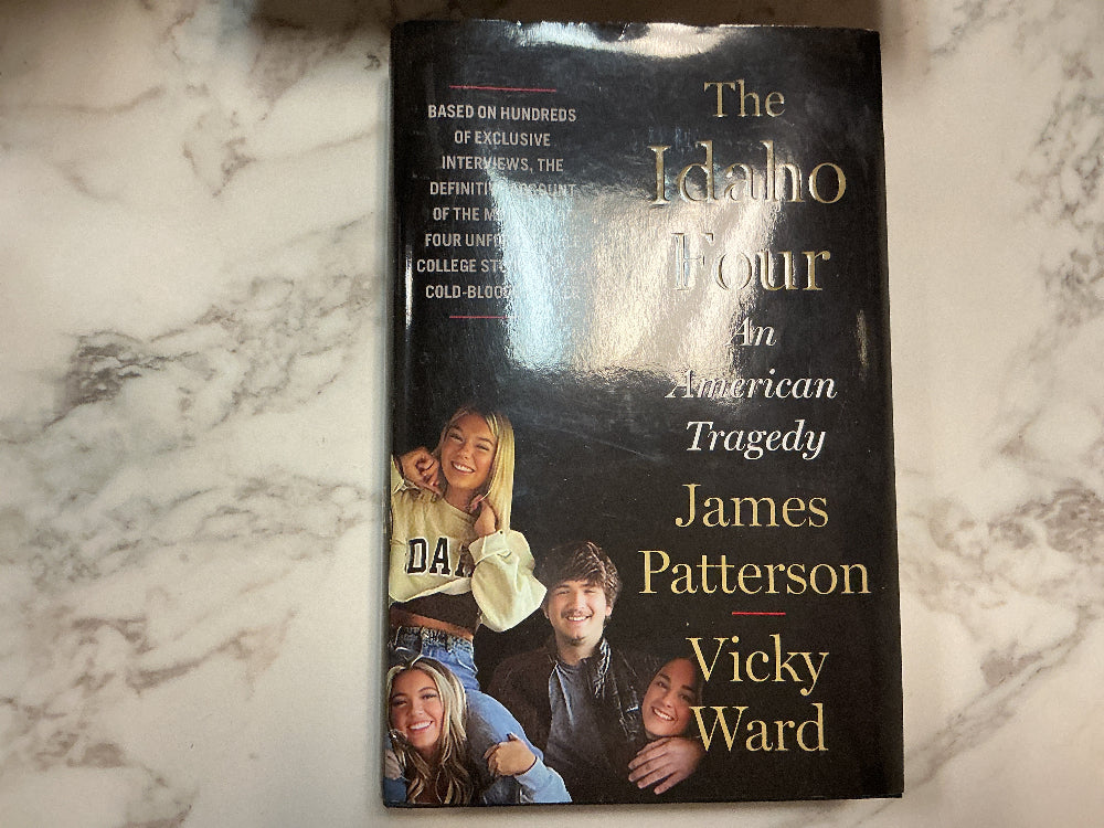 Book titled 'The Idaho Four' by James Patterson and Vicky Ward on a marble surface