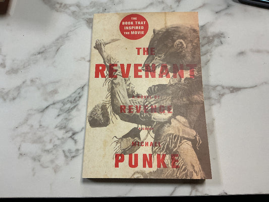 Book titled 'The Revenant' by Michael Punke on a marble surface