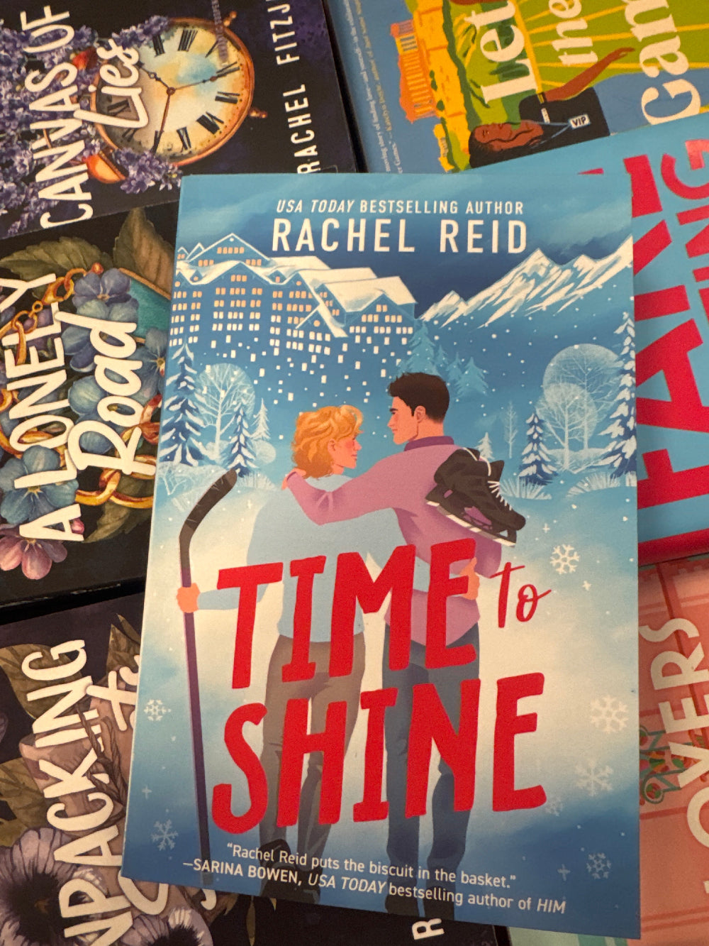 Book titled 'Time to Shine' by Rachel Reid among other books on a colorful background