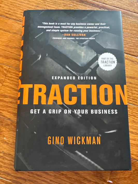 Traction book by Gino Wickman hardcover with orange title and tire tread design