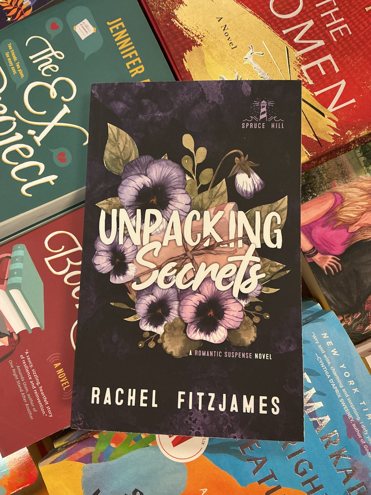 Unpacking Secrets book by Rachel Fitzjames with purple pansy cover and lighthouse logo