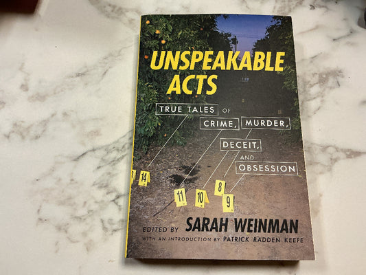 Book titled 'Unspeakable Acts' on a marble surface