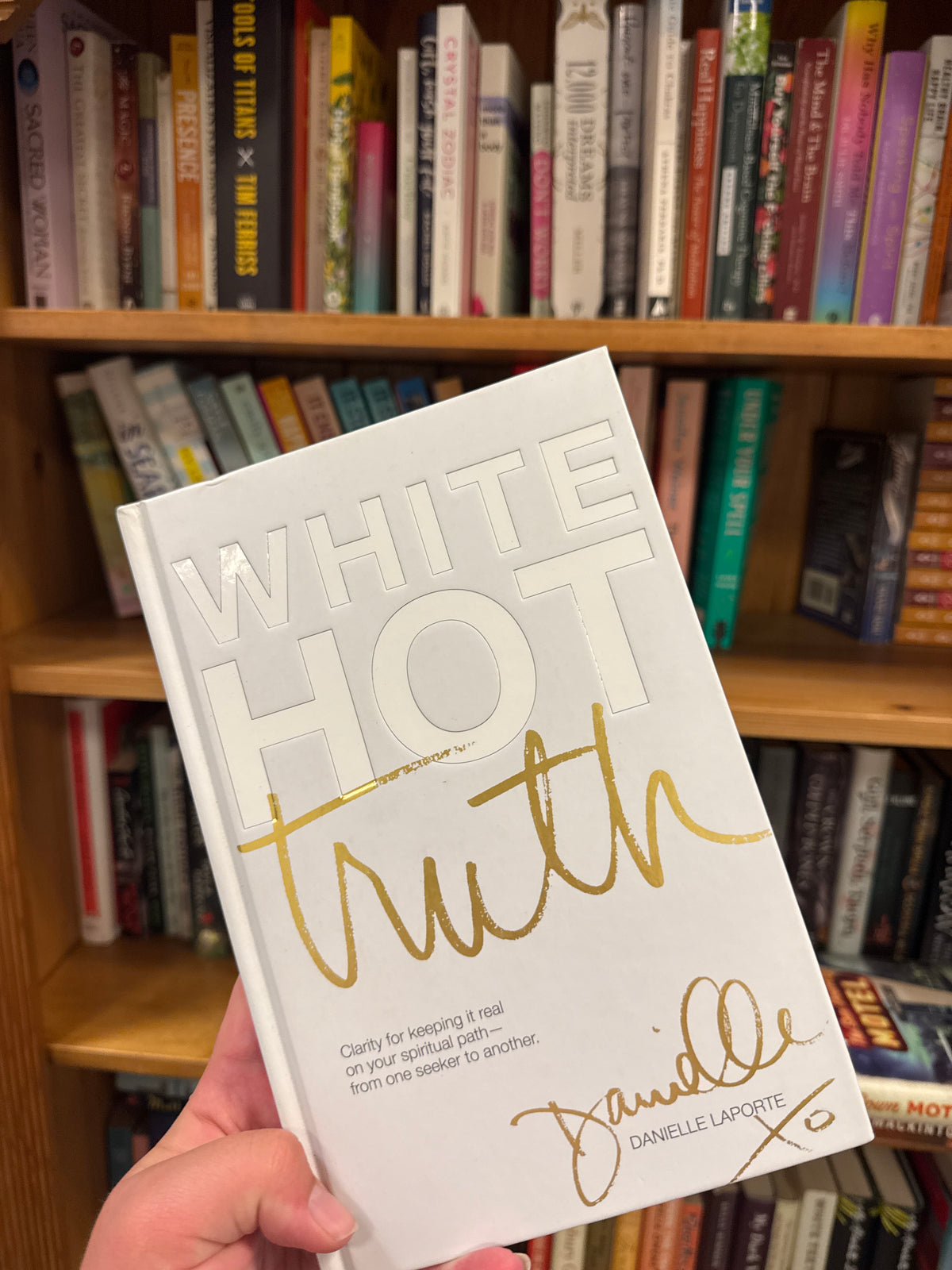 White Hot Truth hardcover book by Danielle Laporte on wooden bookshelf