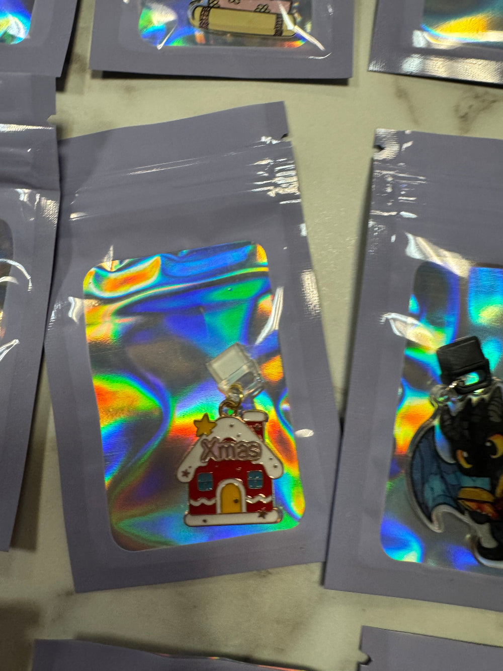 Holographic packaging with xmas house kindle charm in it