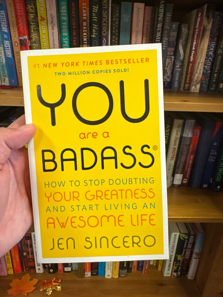 You Are a Badass paperback book by Jen Sincero with yellow cover